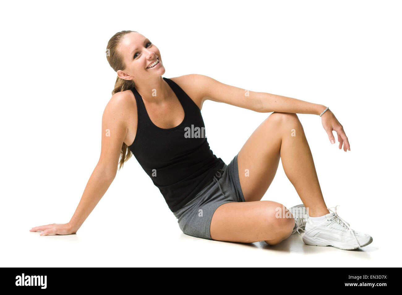 Studio shot di sorridere giovane donna di indossare abbigliamento sportivo Foto Stock