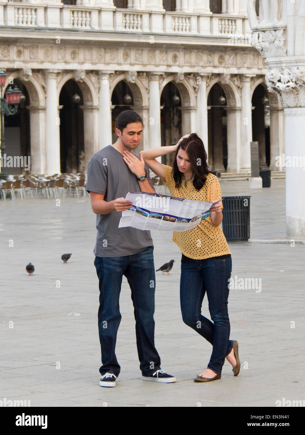 L'Italia, Venezia, coppia giovane guardando la mappa su Piazza San Marco Foto Stock