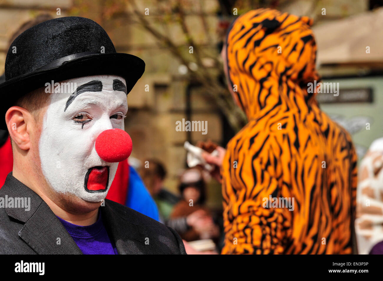 Clown con il bianco faccia dipinta e naso rosso indossando un cappello in The Guildhall Square, Derry, Londonderry, Irlanda del Nord. Foto Stock