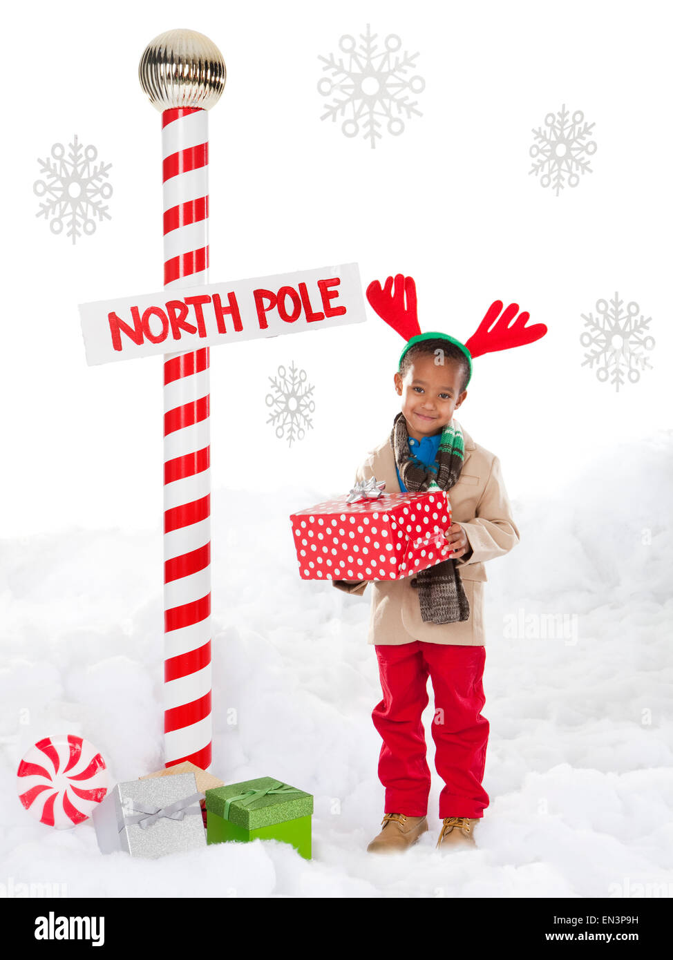 Ragazzo (4-5) indossando le renne palchi in piedi accanto al Polo Nord segno Foto Stock