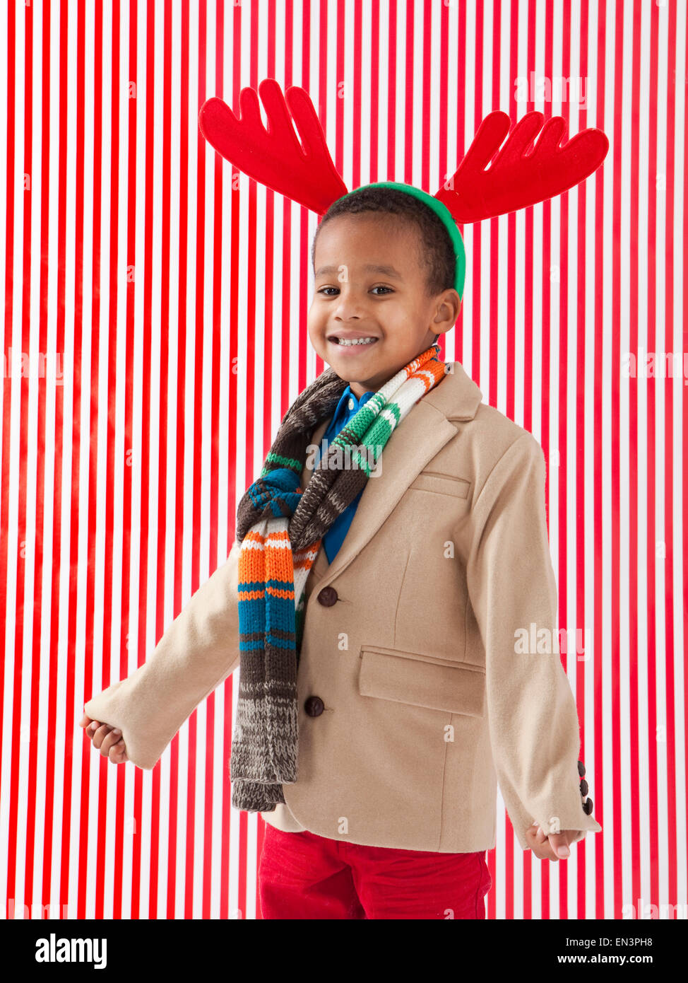 Ragazzo (4-5) indossando corna di renne, studio shot Foto Stock