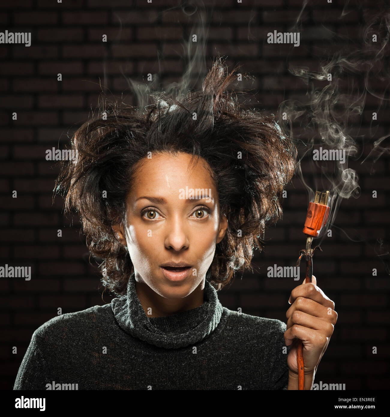 Studio shot di donna tenendo il fumo spina elettrica Foto Stock