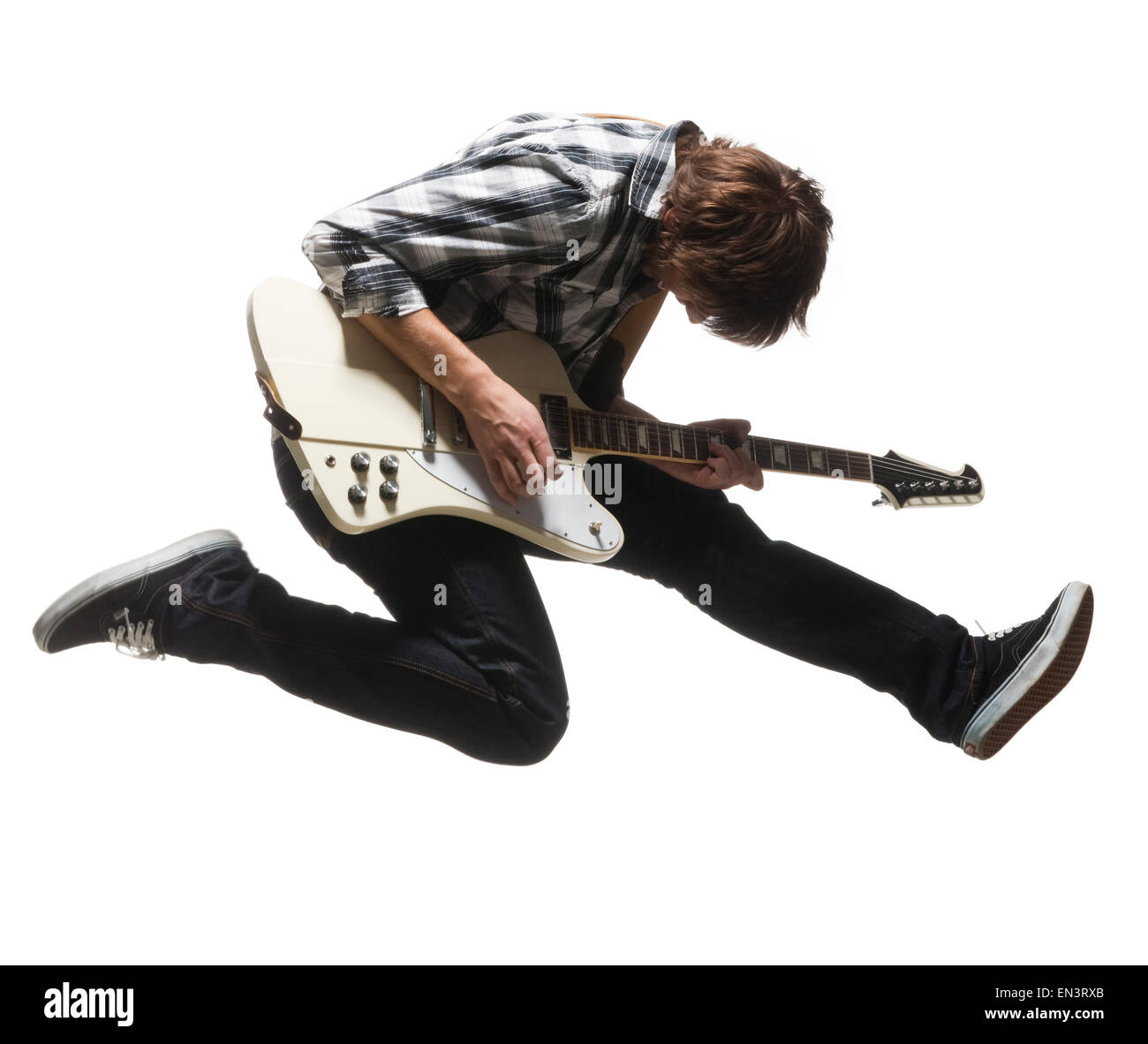 Studio shot del giovane (18-19) i salti in aria mentre suonando la chitarra Foto Stock