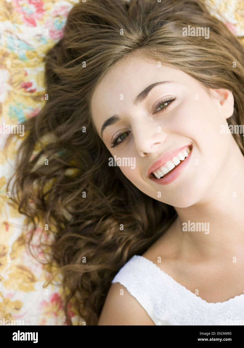 Donna sdraiata su una stampa floreale coperta Foto Stock