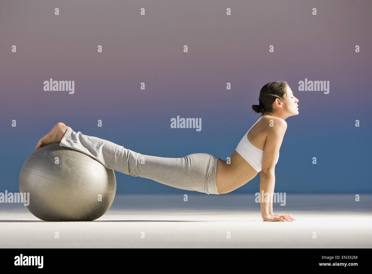 Donna che rotola su di una sfera di svizzera Foto Stock