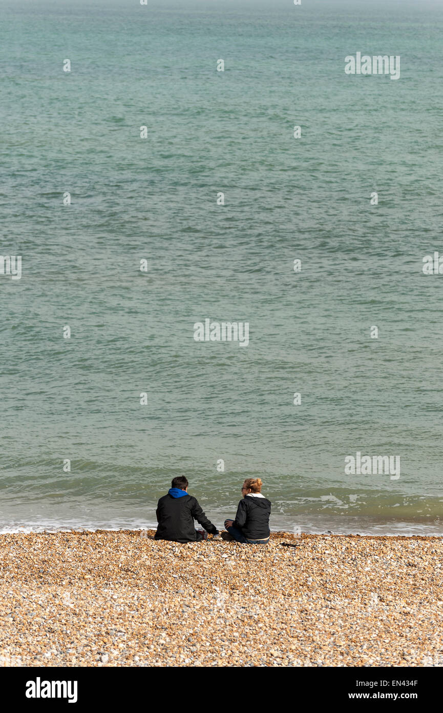 Eastbourne, Regno Unito. Xxv Aprile, 2015. Regno Unito Meteo: un paio di sedersi sulla spiaggia di ciottoli di trascorrere un piacevole pomeriggio di primavera a Eastbourne in Inghilterra del sud costa . © Stephen Chung / Alamy Live News Foto Stock