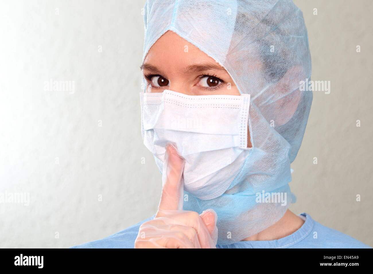 Un medico di sesso femminile con il dito sulle labbra Foto Stock