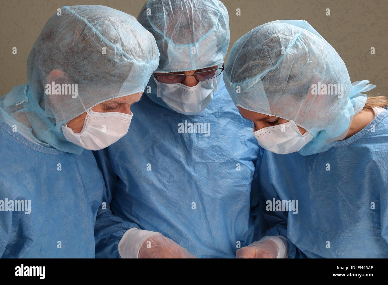 Tre medici lavorano concentrato in una sala OP Foto Stock