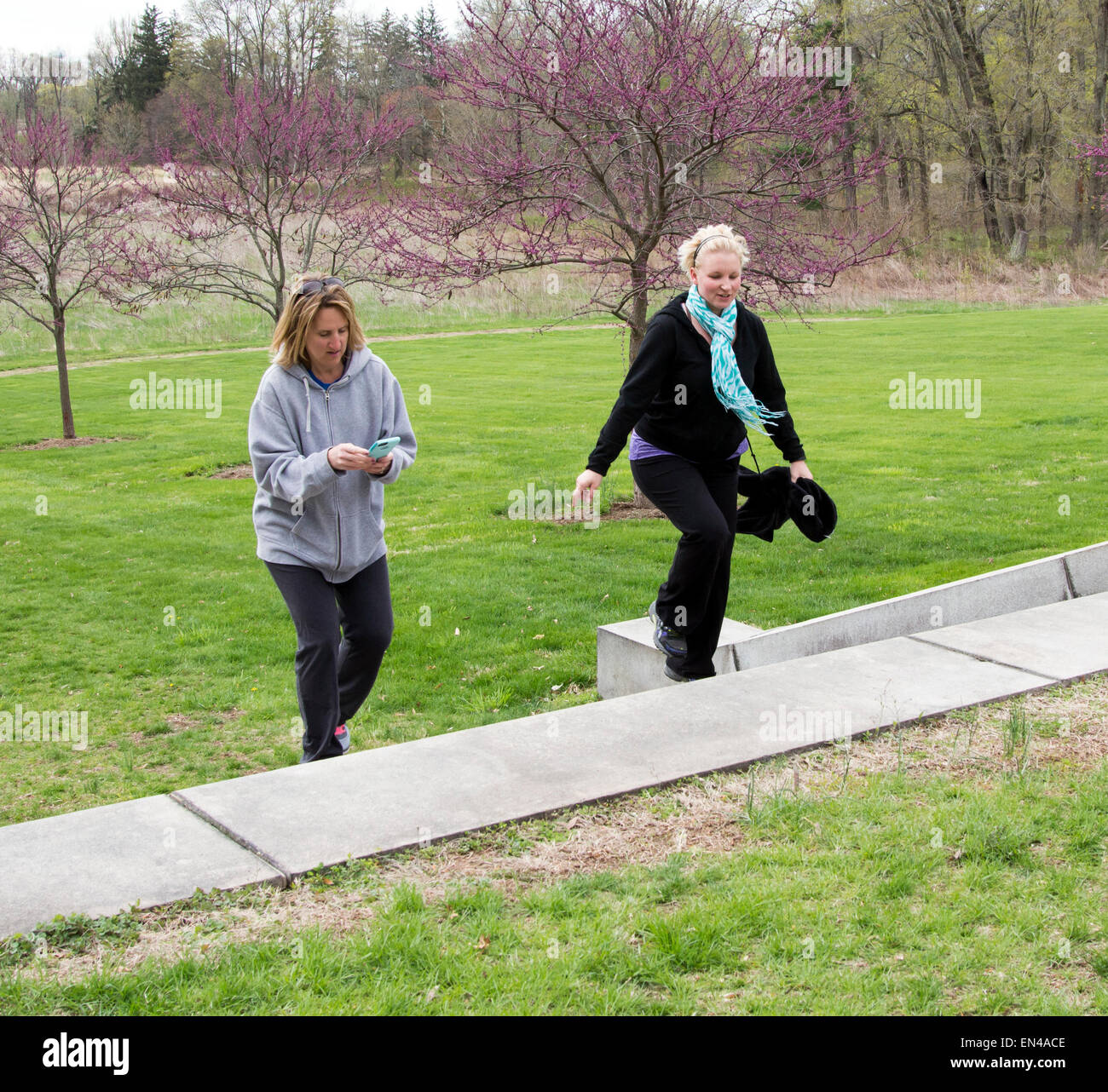 Due donne a salire le scale all'aperto a parlare e tramite cellulare. Foto Stock