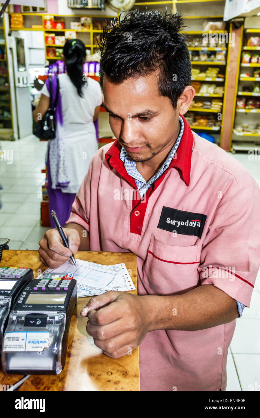 Mumbai India,Churchgate,Suryodaya,negozio di alimentari,supermercato,uomo uomo maschio,lavoratori dipendenti lavoratori dipendenti personale di lavoro,carta di credito scanner,utilizzando,uniforme,India Foto Stock