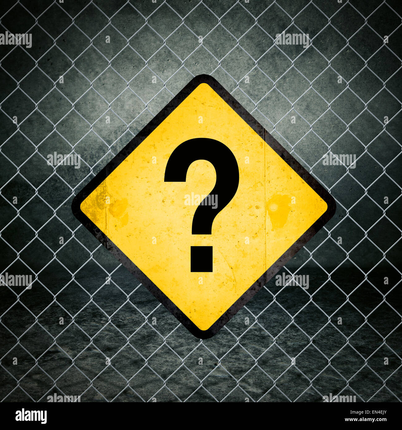 Punto interrogativo giallo Grunge segno di avvertimento sulla catena collegamento recinto di magazzini industriali Foto Stock