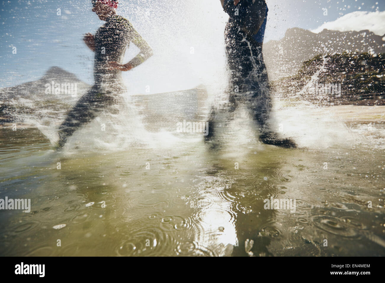 Immagine di spruzzi di acqua mentre triatleti in esecuzione nel lago. Gli atleti della formazione per la gara di triathlon. Foto Stock