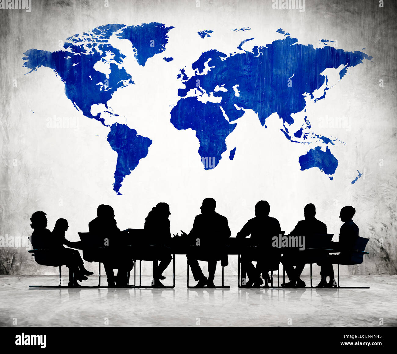 La gente di affari discutendo attorno al tavolo da conferenza e una cartografia blu del mondo di cui sopra. Foto Stock