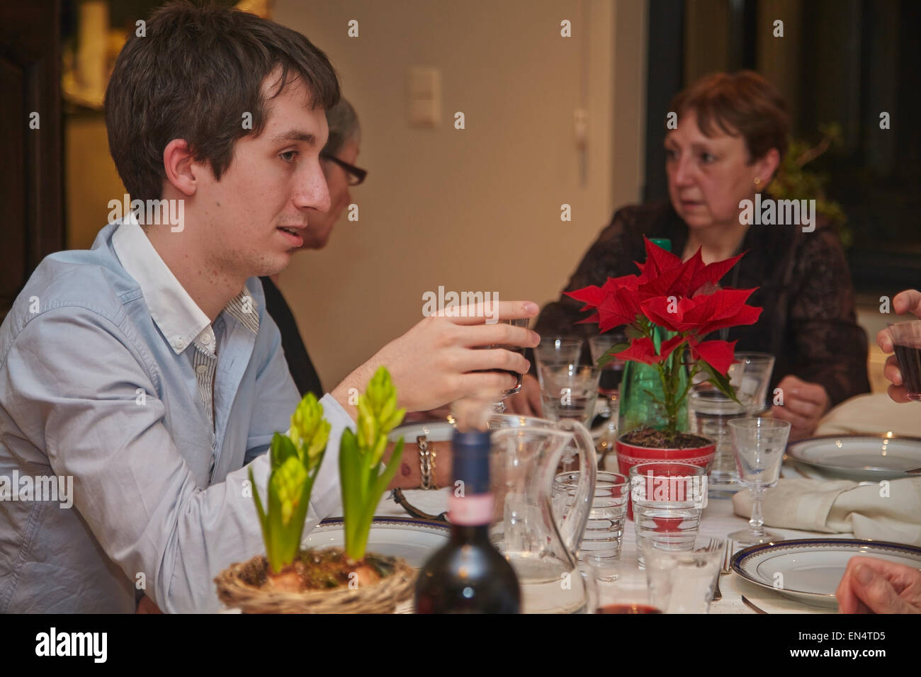 Un giovane a una festa di Capodanno con cena in famiglia; a Bruxelles, Belgio. Foto Stock