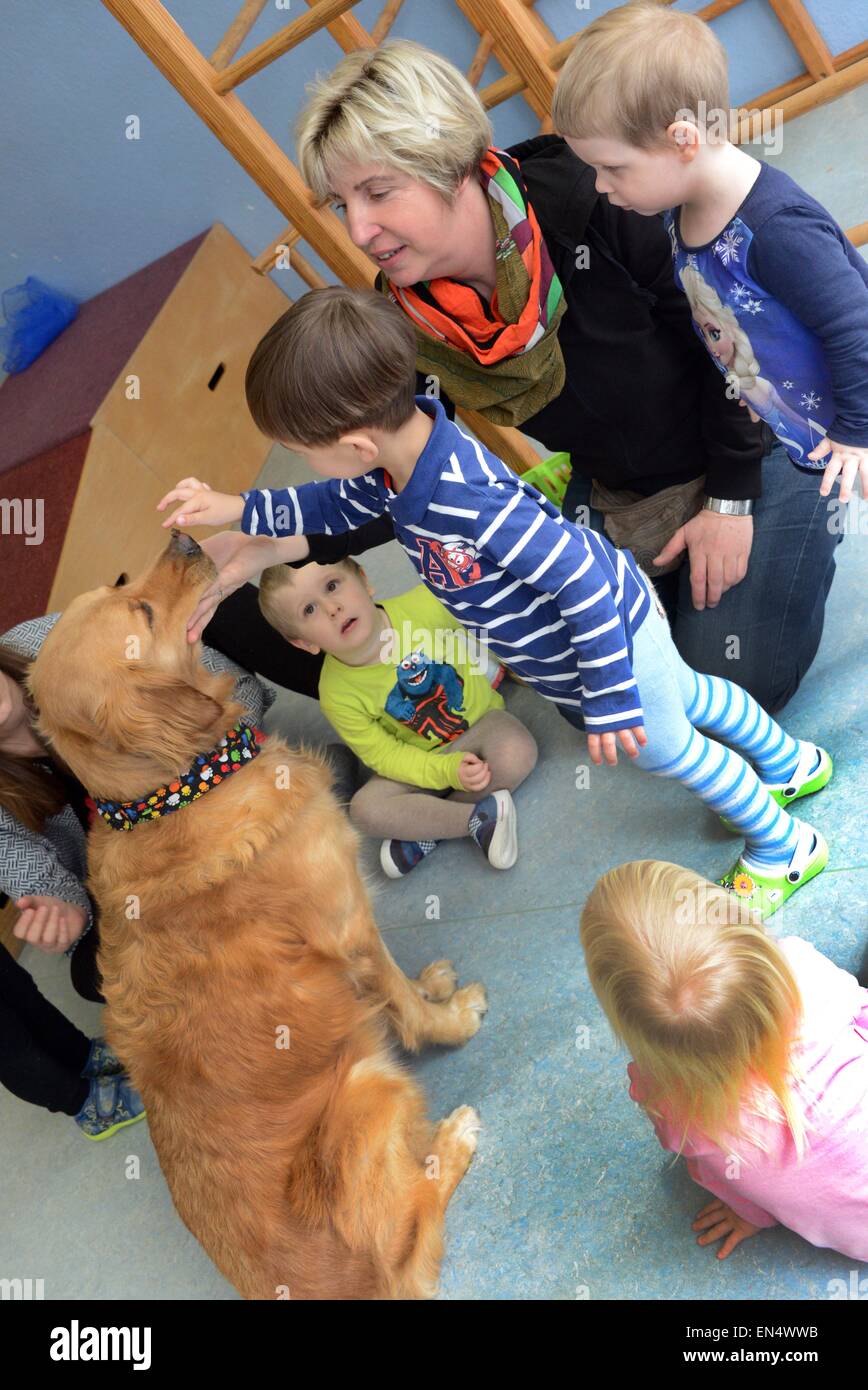 Halle, Germania. 24 Mar, 2015. La testa del vivaio-scuola Constanze Stock (2R) dimostra asilo nido i bambini come gestire e trattare 'Balu', un retriever, presso la struttura diurni per bambini "Froschkoenig' a Halle, Germania, 24 marzo 2015. "Balu' è l'asilo nido il proprio cane ed è stato appositamente addestrato come parte di un linguaggio e di integrazione" programma, sostenuto dal Ministero tedesco degli Affari Familiari, per favorire lo sviluppo del linguaggio dei bambini negli asili e scuole. Foto: Waltraud Grubitzsch/dpa/Alamy Live News Foto Stock