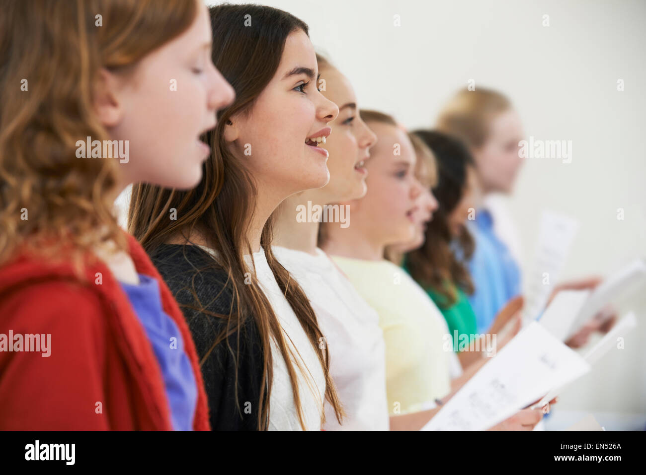 Un gruppo di bambini della scuola di cantare in coro insieme Foto Stock