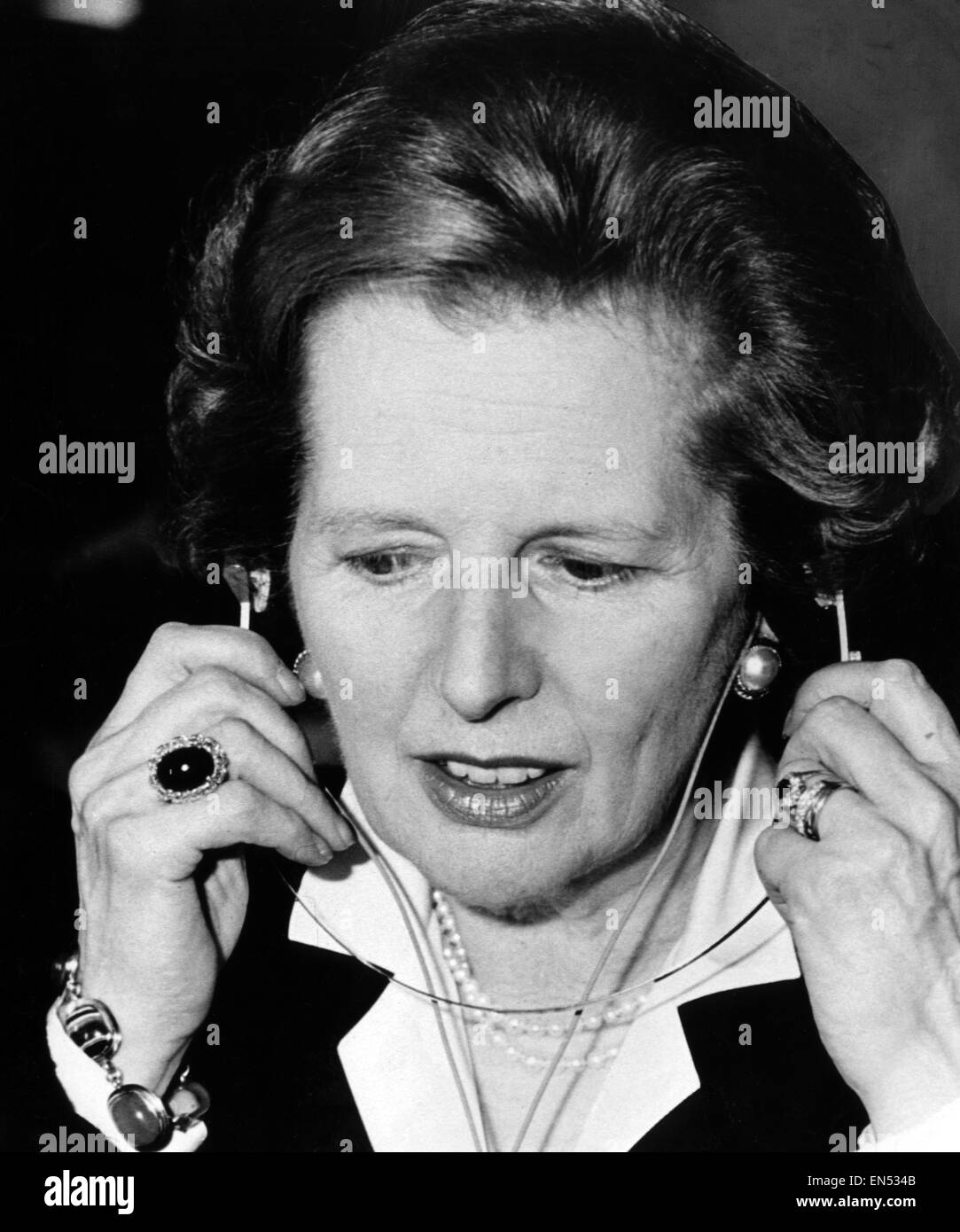 Il Primo Ministro Margaret Thatcher tenta di eseguire un paio di cuffie - amplificatori audio - al Marconi in Scozia 2 Giugno 1987. Foto Stock