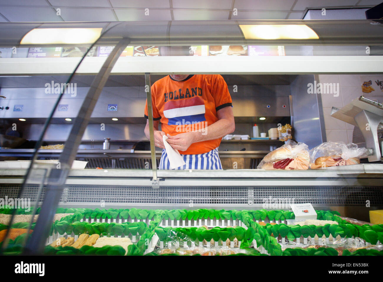 Un uomo con una t-shirt lavora in uno snackbar sulla re della giornata è visto. Foto Stock