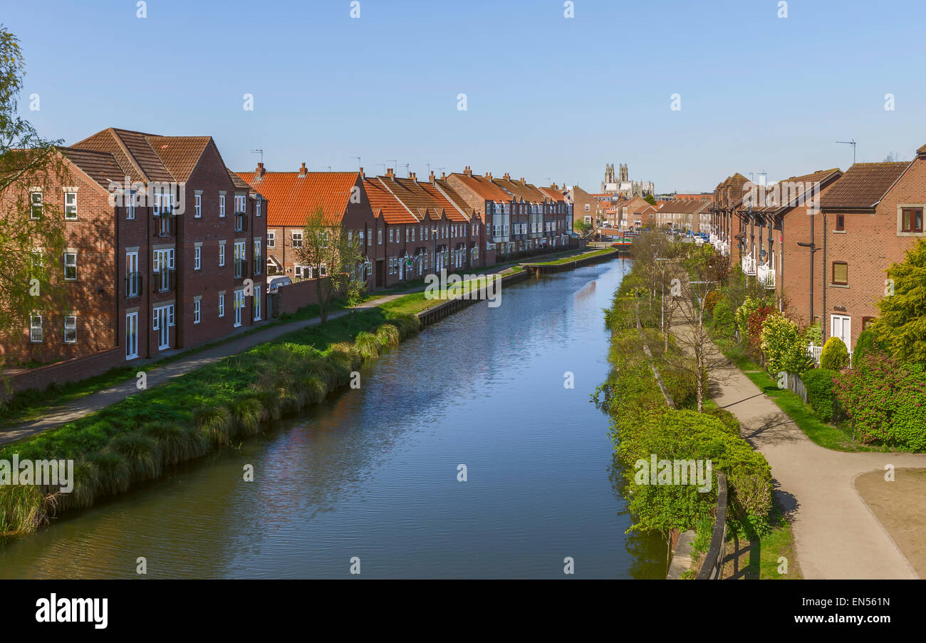 Vista lungo la Beck (canale) fiancheggiato da case residenziali con il ministro (chiesa) all'orizzonte a Beverley, nello Yorkshire, Regno Unito. Foto Stock