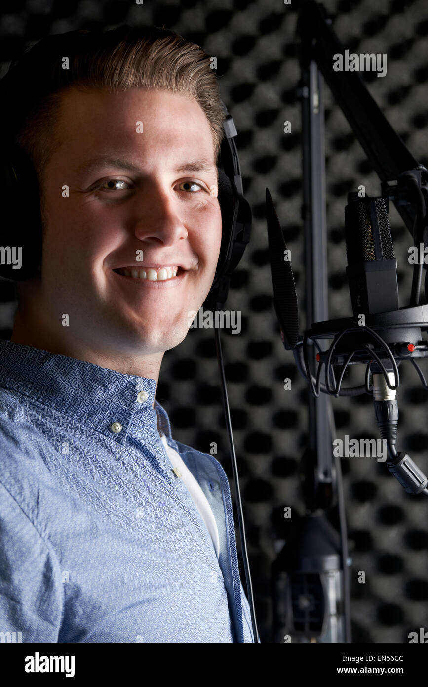 Uomo in studio di registrazione parlando nel microfono Foto Stock