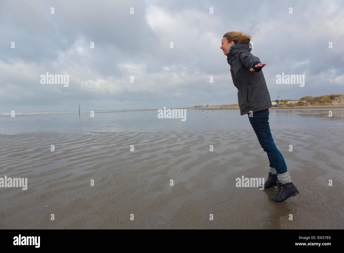 Donna in piedi contro il vento in Olanda Foto Stock