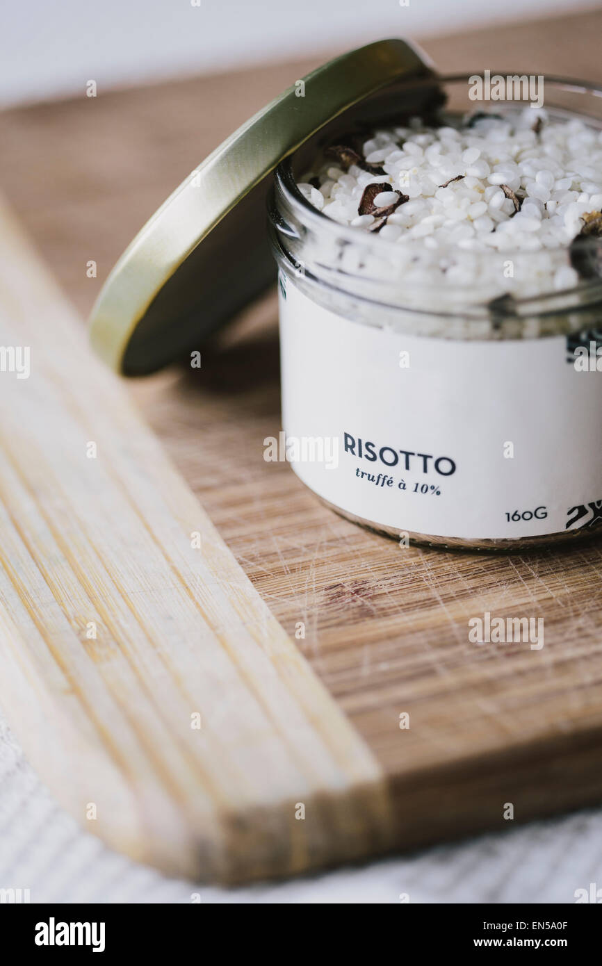 Non cotti riso per risotti con tartufo nero trucioli in un vasetto di vetro con il coperchio rimosso Foto Stock