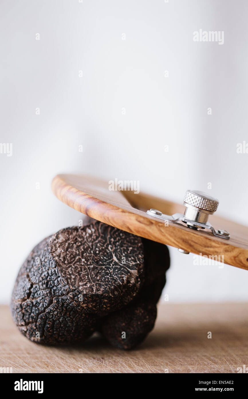 Tutto il tartufo nero di close-up di legno con lama di rasatura Foto Stock