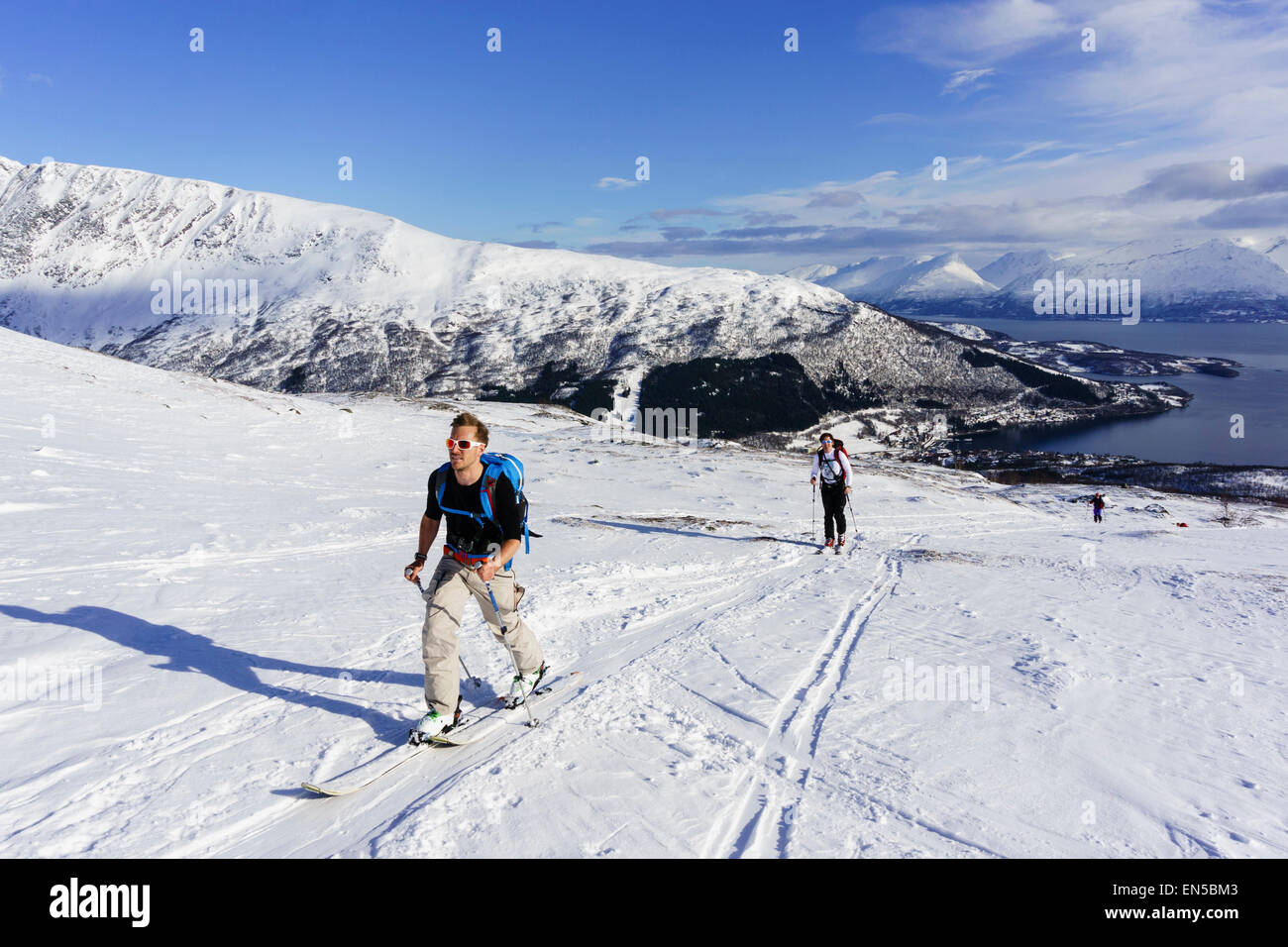 Gli sciatori di scialpinismo la salita con le pelli sulla strada Rornefjellet montagna sopra Lyngenfjord. Alpi Lyngen Troms County in Norvegia. Foto Stock