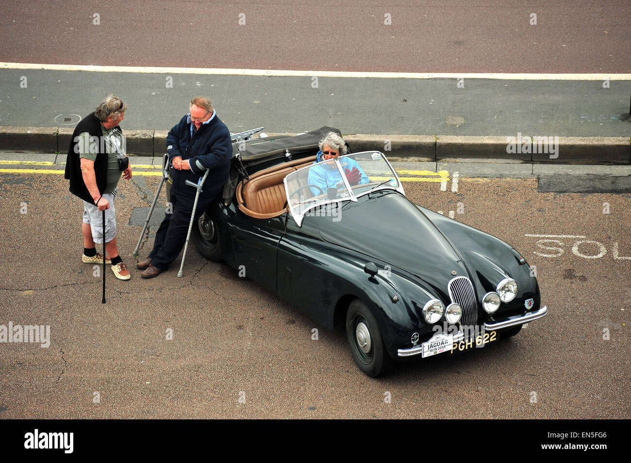 Jaguar gli appassionati di auto si raccolgono intorno ad un classico Jaguar parcheggiata lungo a Madera per guidare un auto show di Brighton. Foto Stock