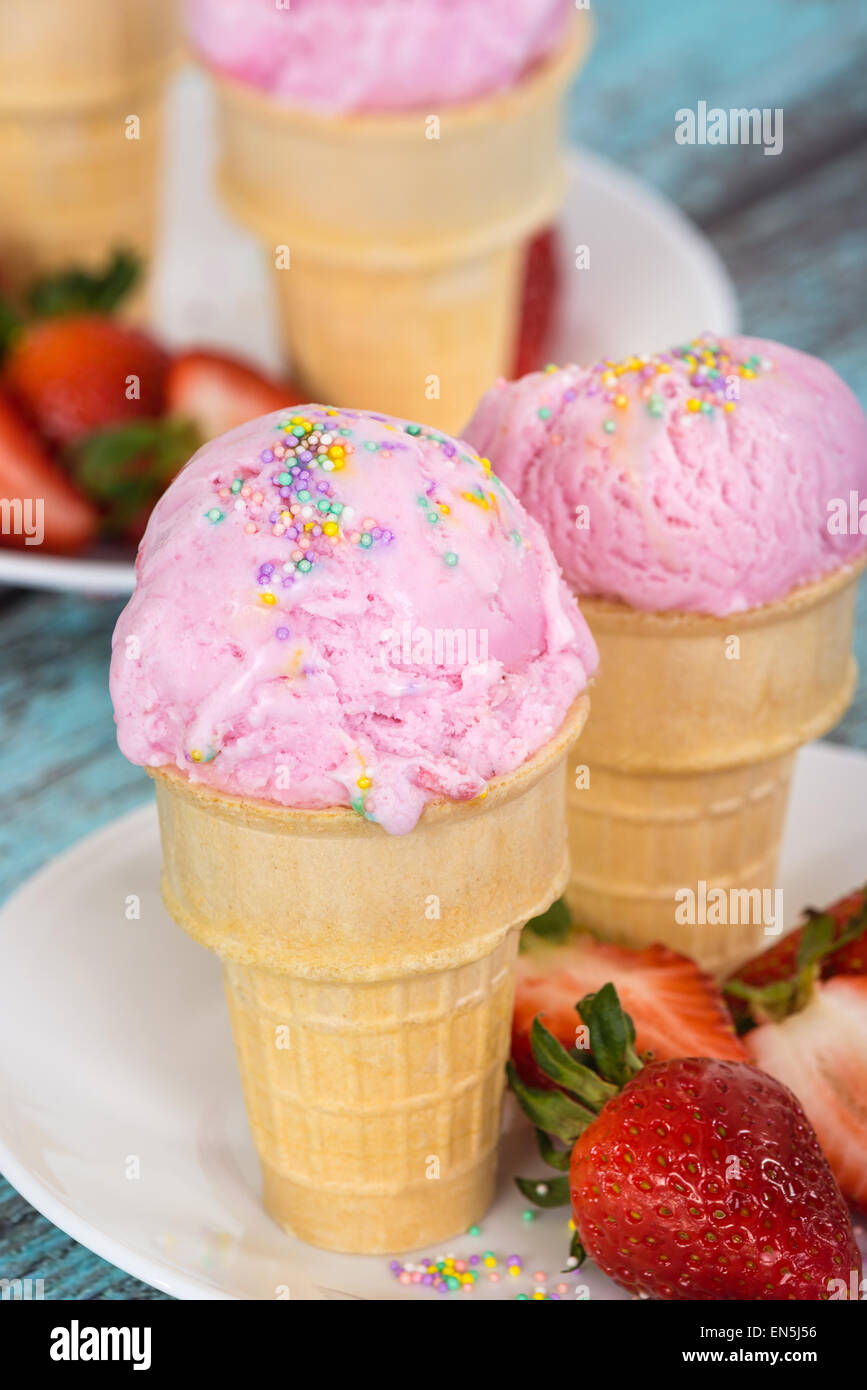 Gelato alla fragola con spruzza in waffle tazze contro di legno sfondo vintage Foto Stock