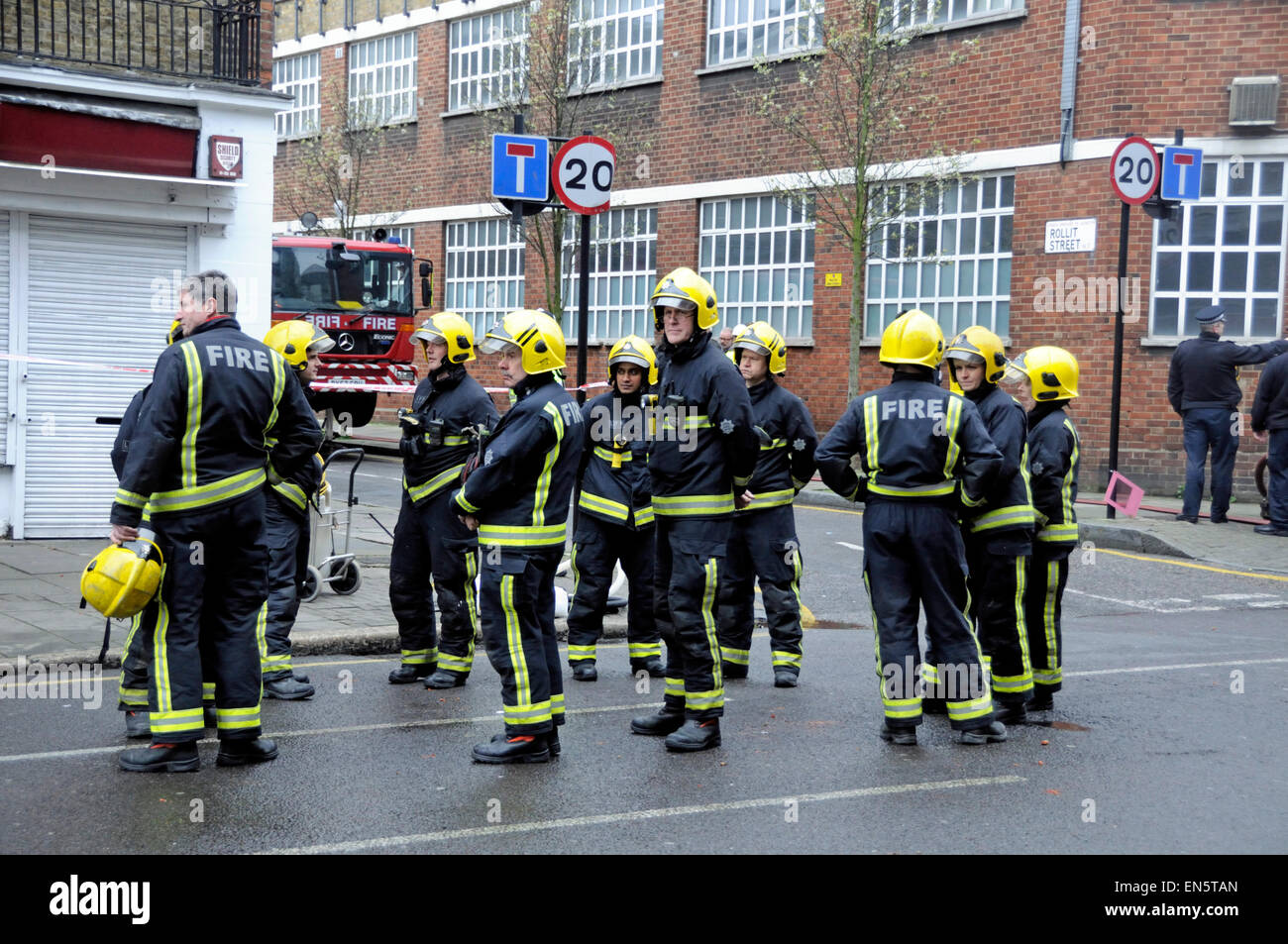 Maschio e femmina degli ufficiali di fuoco in corrispondenza della giunzione di Rollit Street e Hornsey Road, Holloway, nord di Londra dopo un incendio scoppiato ho Foto Stock