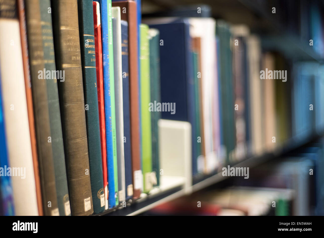 Colorato i libri in biblioteca universitaria di pile shot obliquamente i titoli non visibile Foto Stock