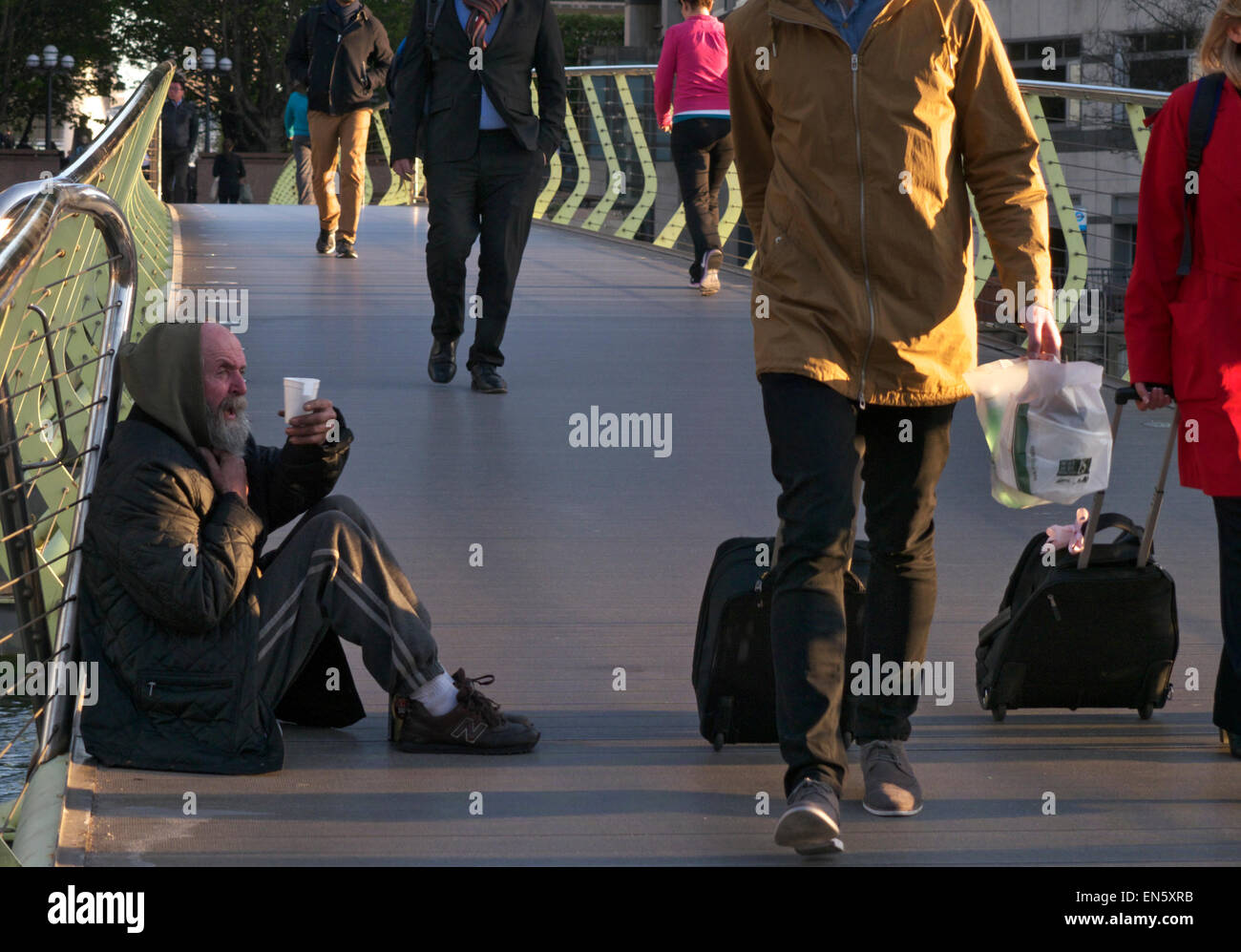 Beggar accattonaggio cup lavoratori passando passerella pubblica della Città distretto finanziario passato a piedi ignorando uomo anziano chiedendo per contanti con la sua tazza di plastica Foto Stock