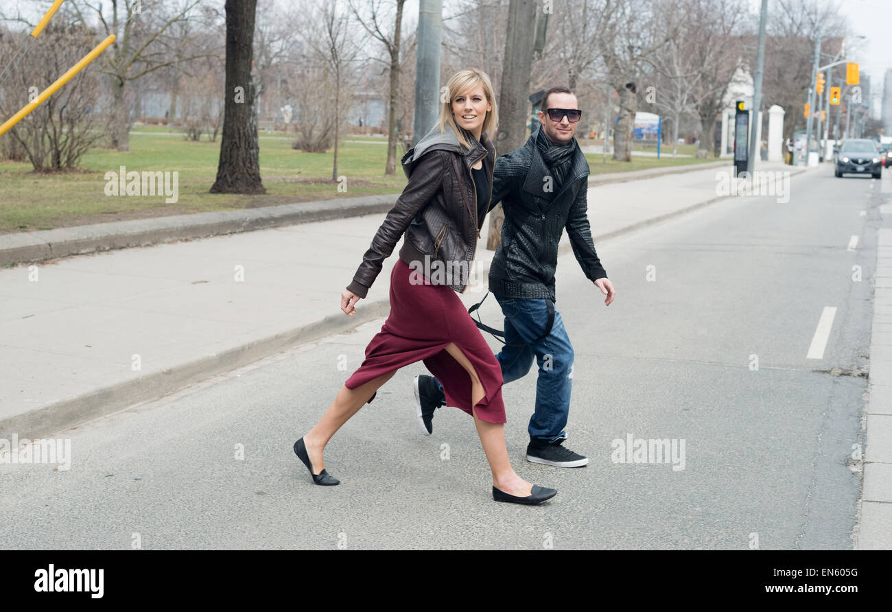 Coppia giovane attraversando via della città Foto Stock