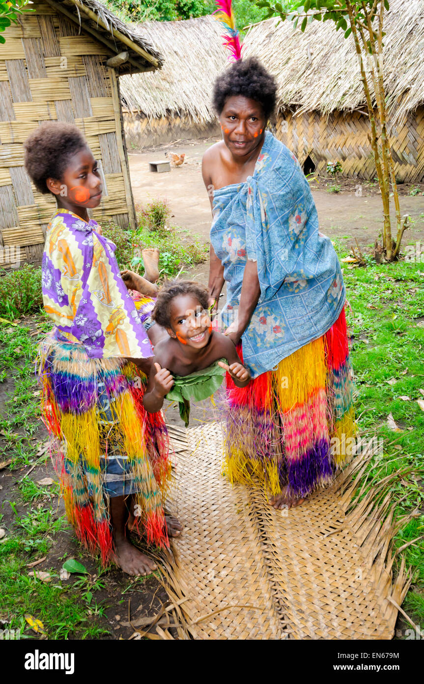 South Pacific Islander donne dimostrando con un bambino di una barella tradizionale fatta di foglie. Tanna, Vanuatu. Isolani del Pacifico, culturale Foto Stock