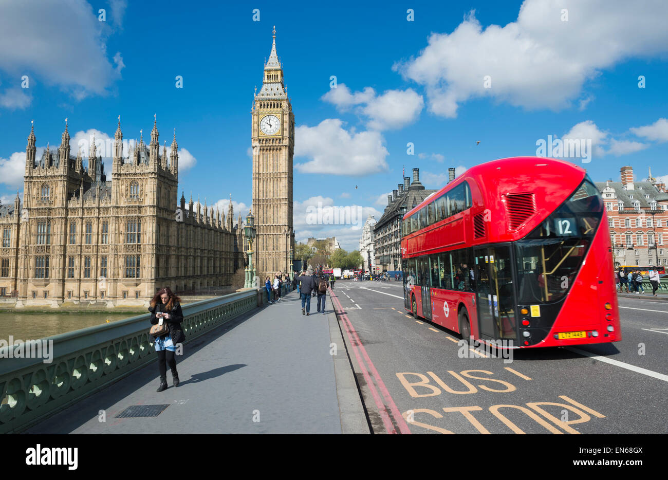 LONDON, Regno Unito - 27 Aprile 2015: modern double-decker bus passa i pedoni a piedi nella parte anteriore del Big Ben e le Camere del Parlamento. Foto Stock