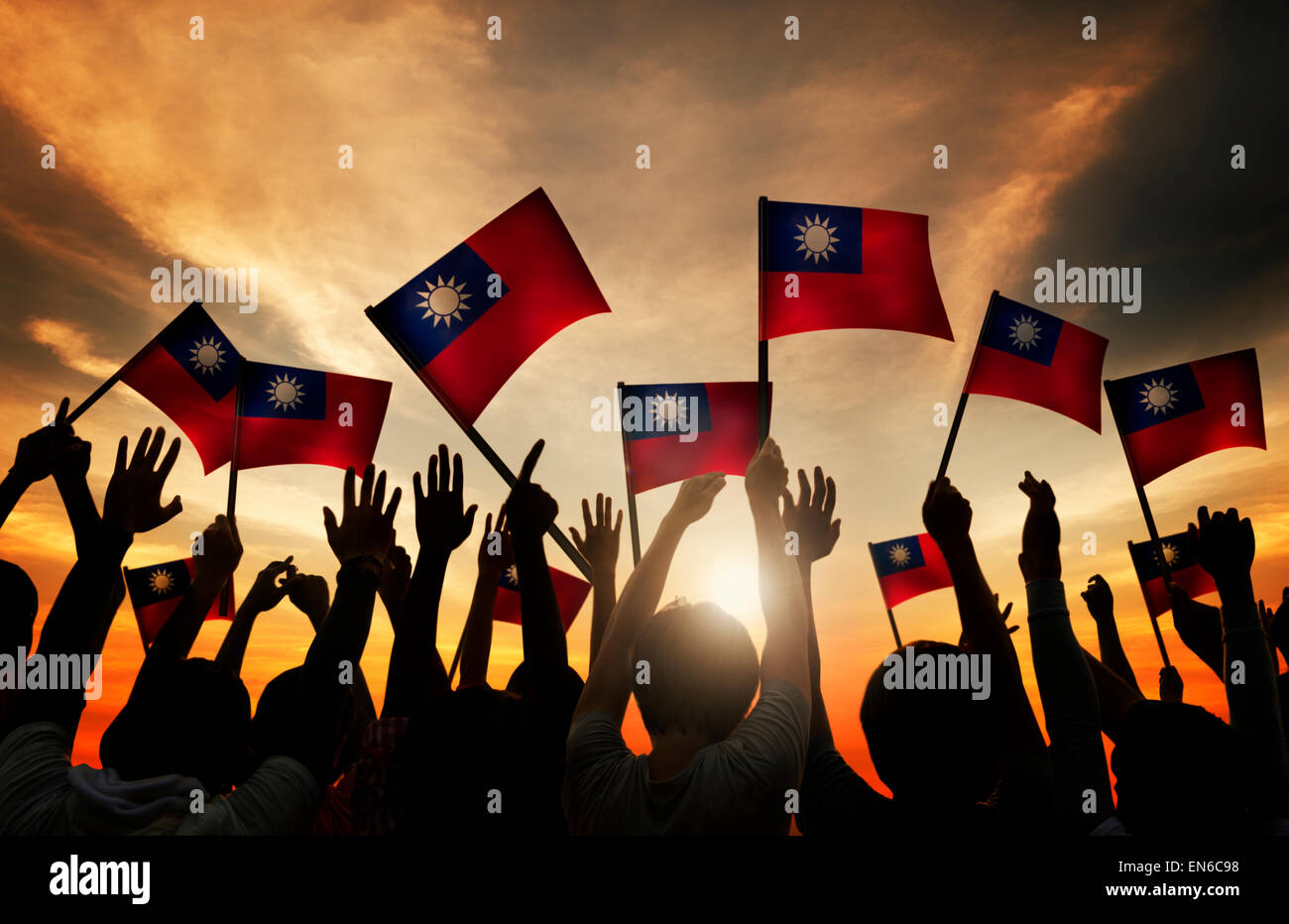 Gruppo di persone che sventolano le bandiere di Taiwan nel retro illuminato Foto Stock