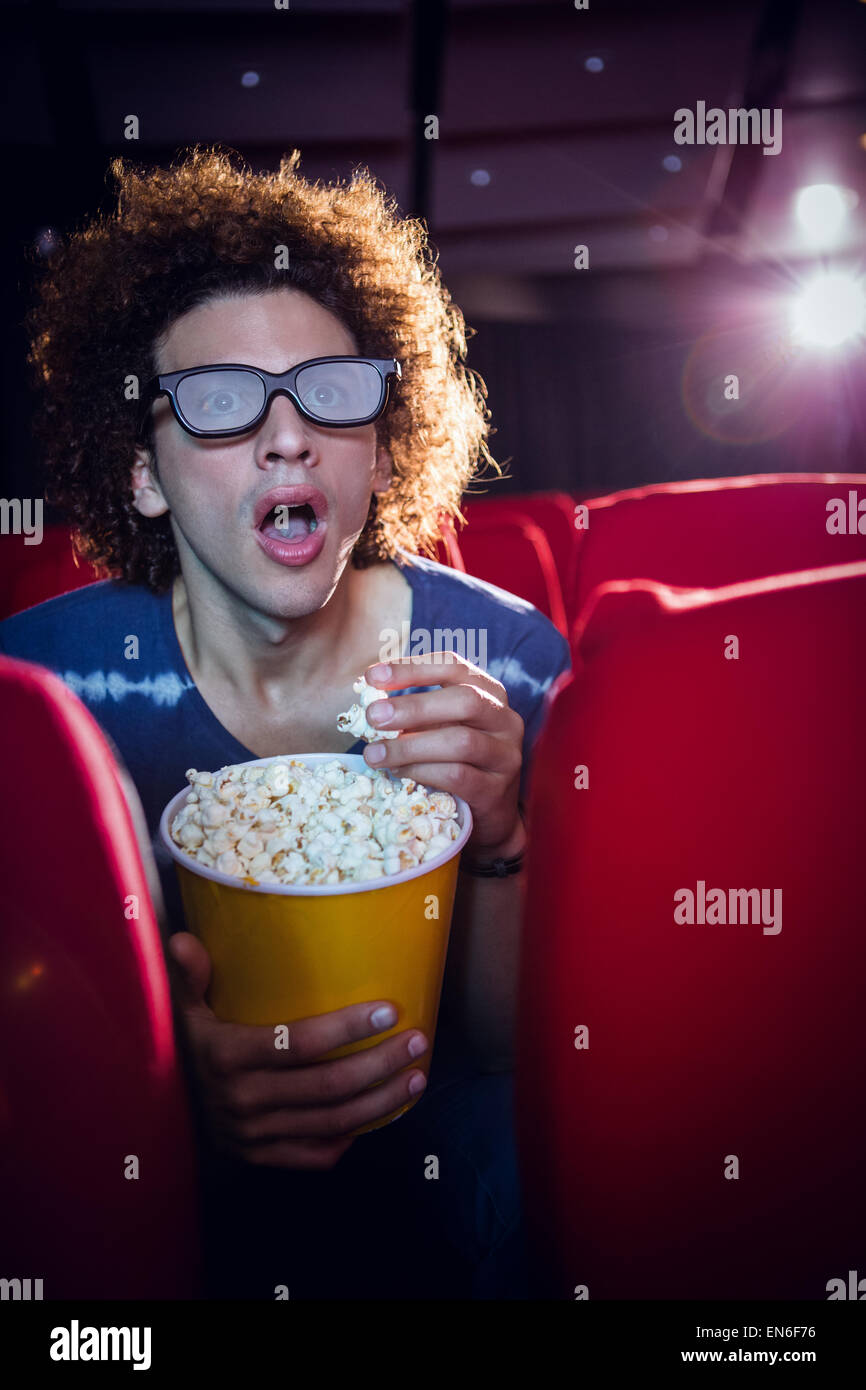 Giovane uomo guardando un film 3d e mangiare popcorn Foto Stock