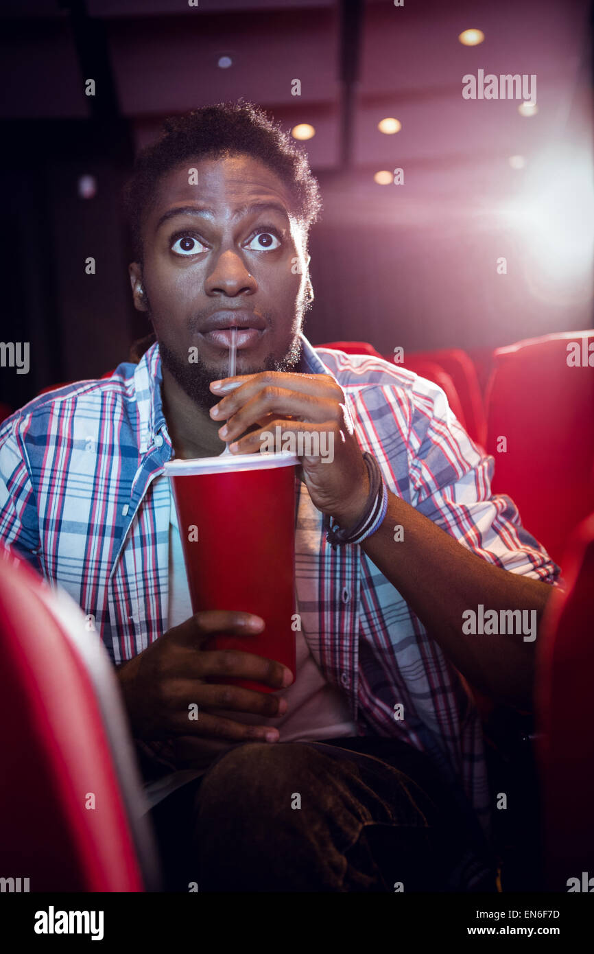 Giovane uomo guardando un film e bevendo soda Foto Stock