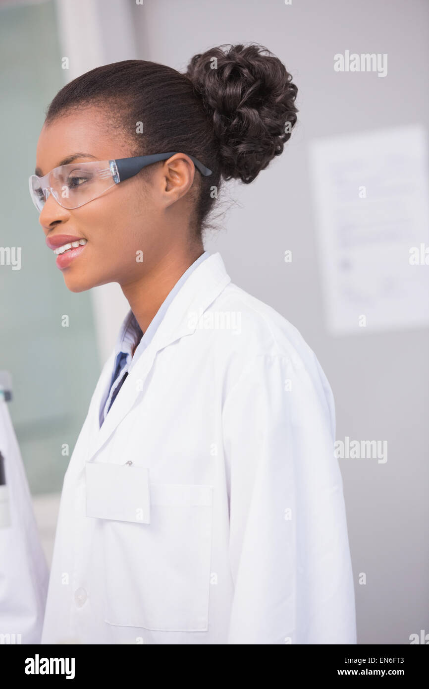 Scienziato sorridente che indossa gli occhiali di protezione Foto Stock