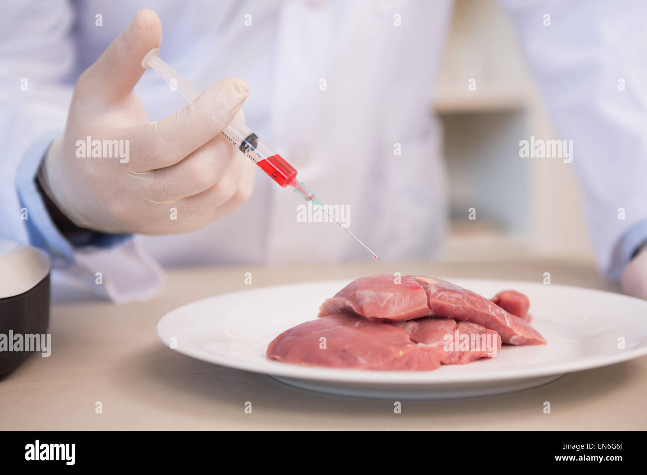 Scienziato iniezione facendo a pezzi di carne Foto Stock