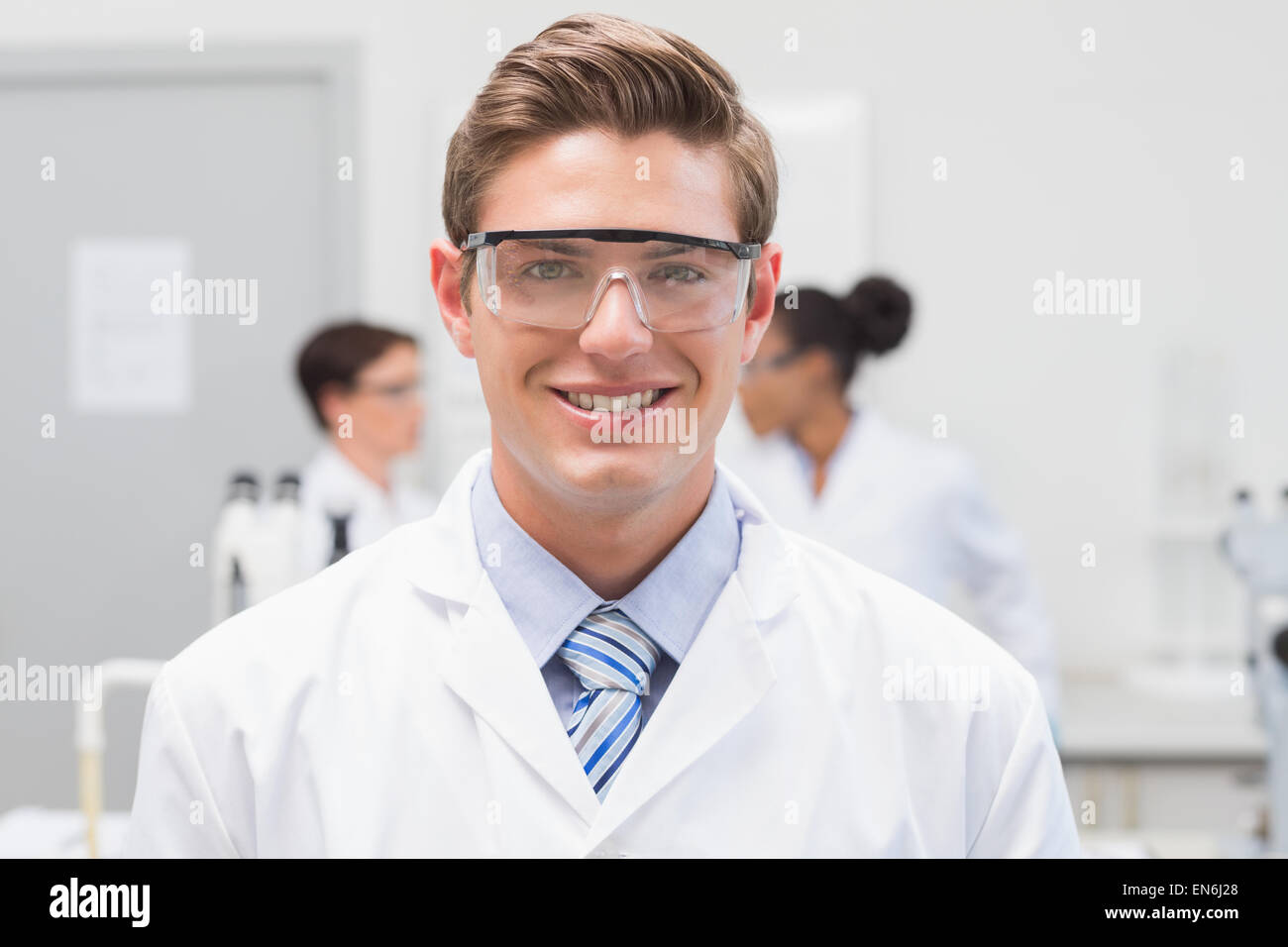 Scienziato felice sorridente in telecamera con gli occhiali di protezione Foto Stock