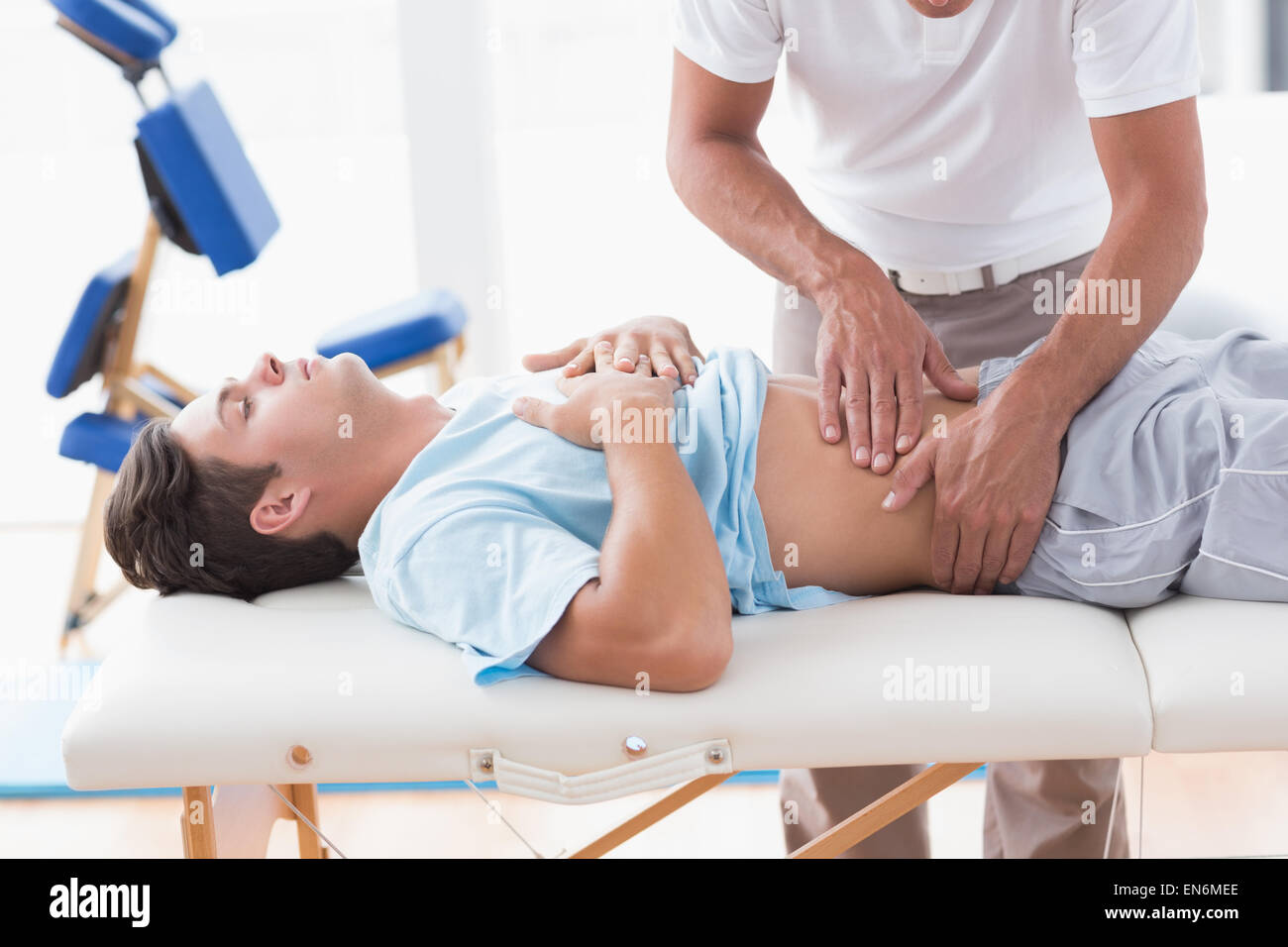 Medico di esaminare il suo stomaco del paziente Foto Stock