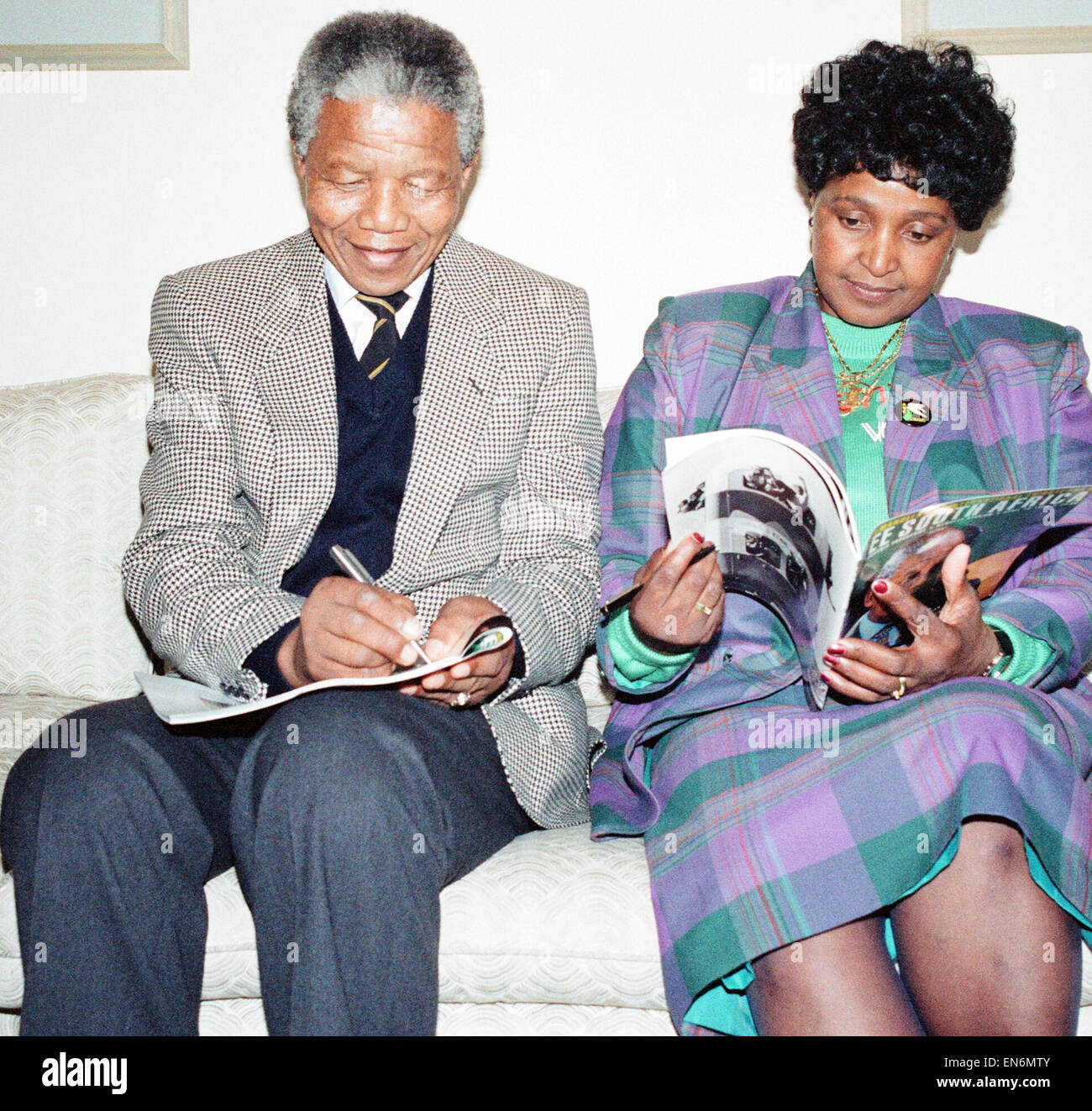 Nelson Mandela leader del Congresso Nazionale Africano (ANC) visto qui rendere note prima di una conferenza stampa al suo arrivo nel Regno Unito, mentre sua moglie Winnie legge una rivista. Il 15 aprile 1990 Foto Stock