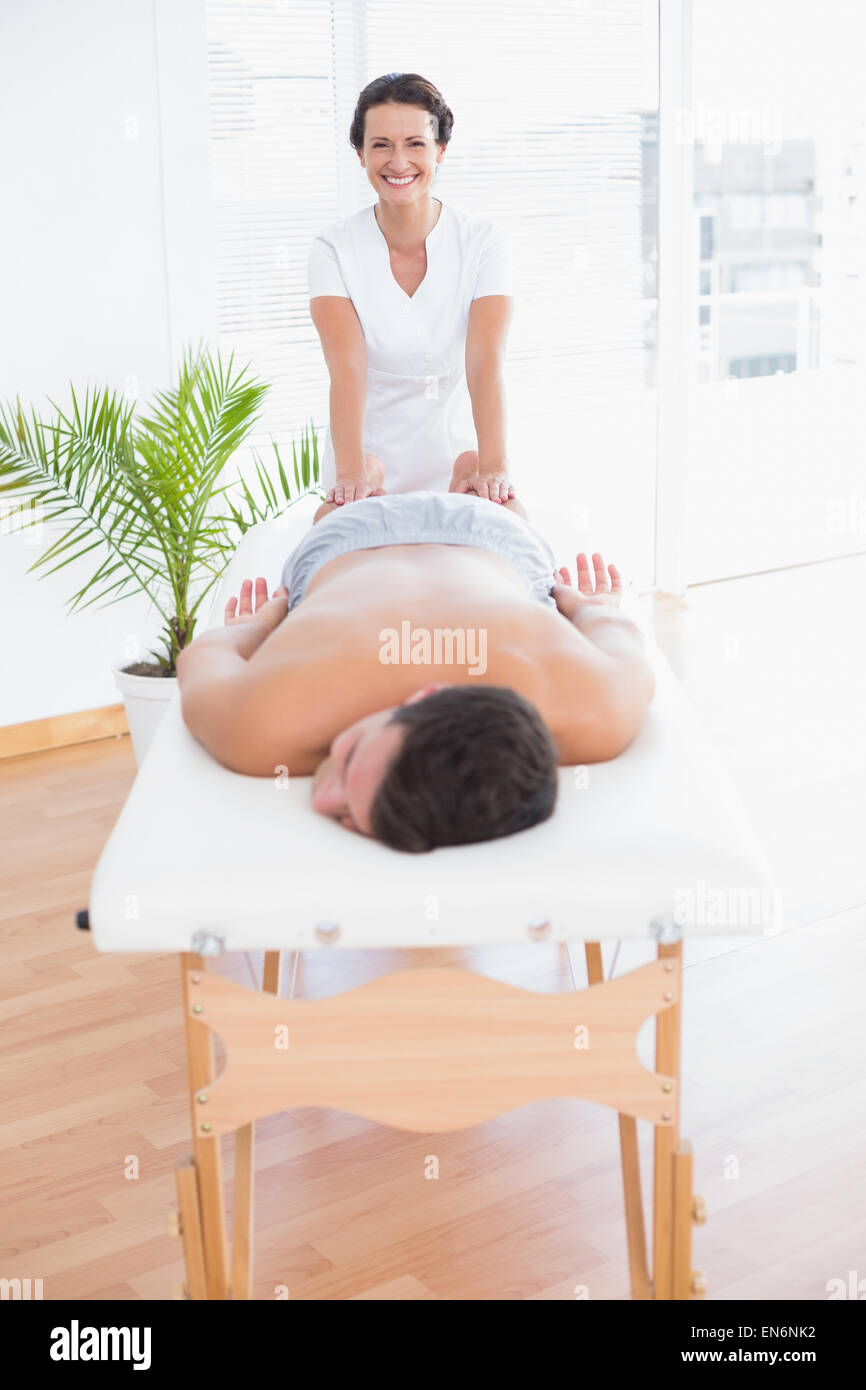 Rilassante del paziente sul lettino da massaggio con fisioterapista dietro Foto Stock