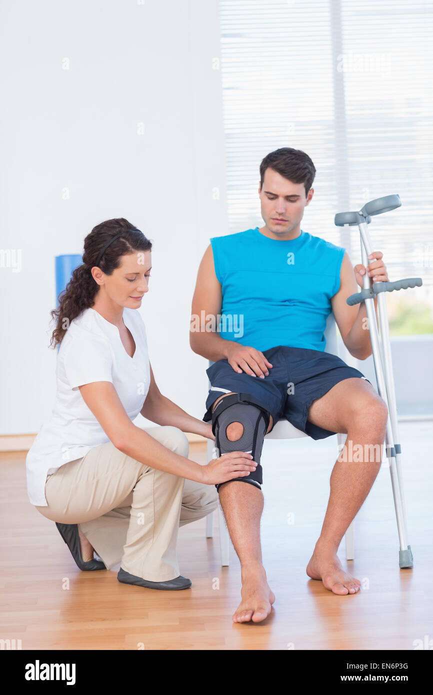 Medico di esaminare il suo ginocchio del paziente Foto Stock