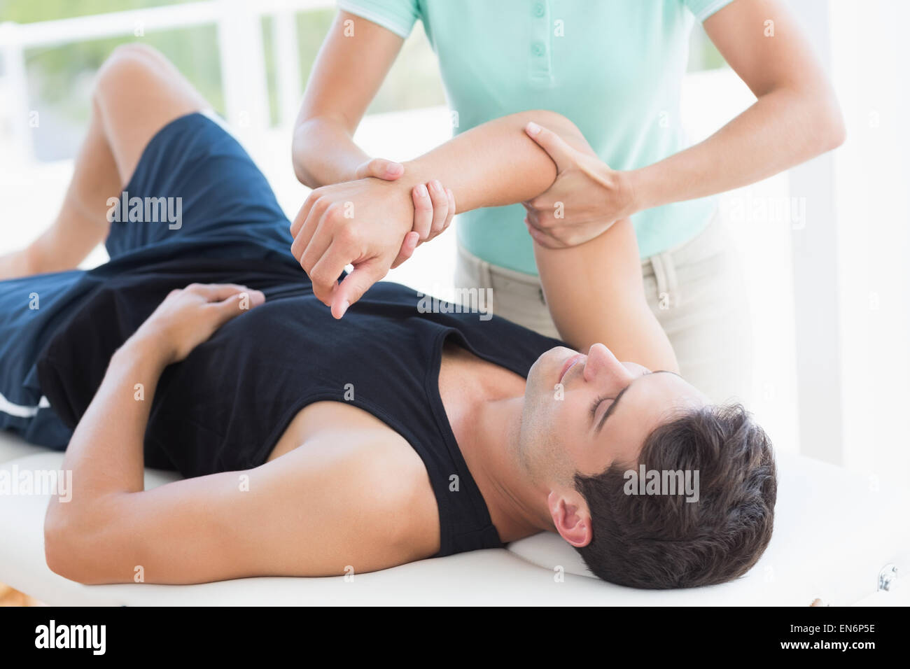 Medico esaminando l uomo braccio Foto Stock