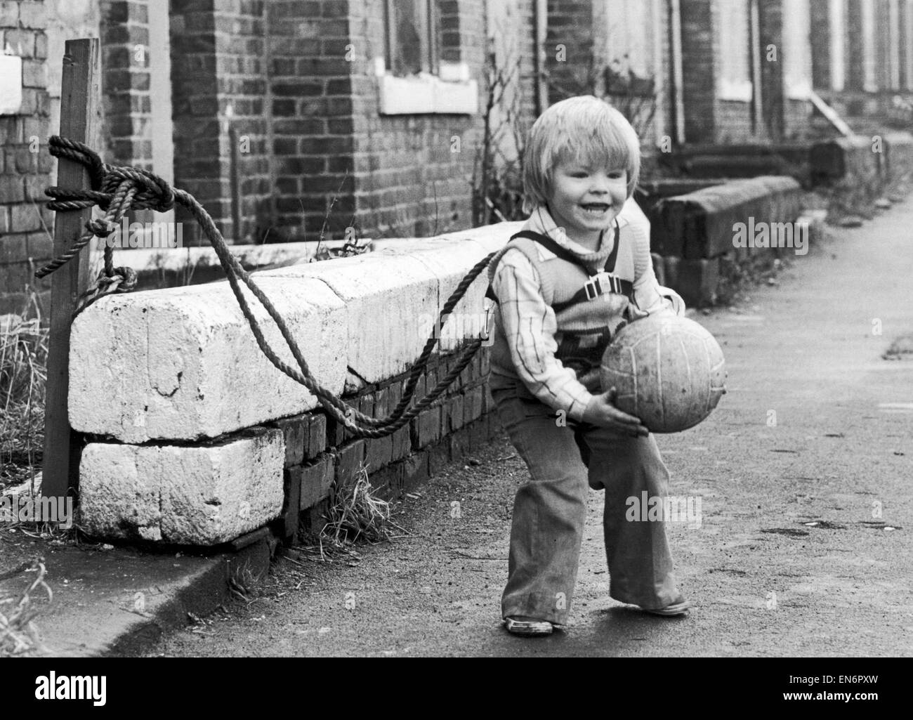 Due anni di Jeffrey Metcalfe che ha quasi stata eseguire più volte è adesso legata a sua mamma per impedire la fuoriuscita di lui quando gioca fuori. Il 15 febbraio 1980. Foto Stock