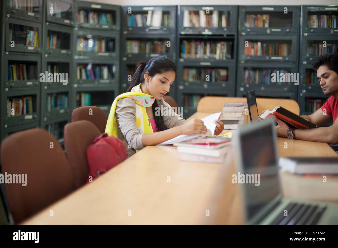 Studente di College leggendo un libro in biblioteca Foto Stock