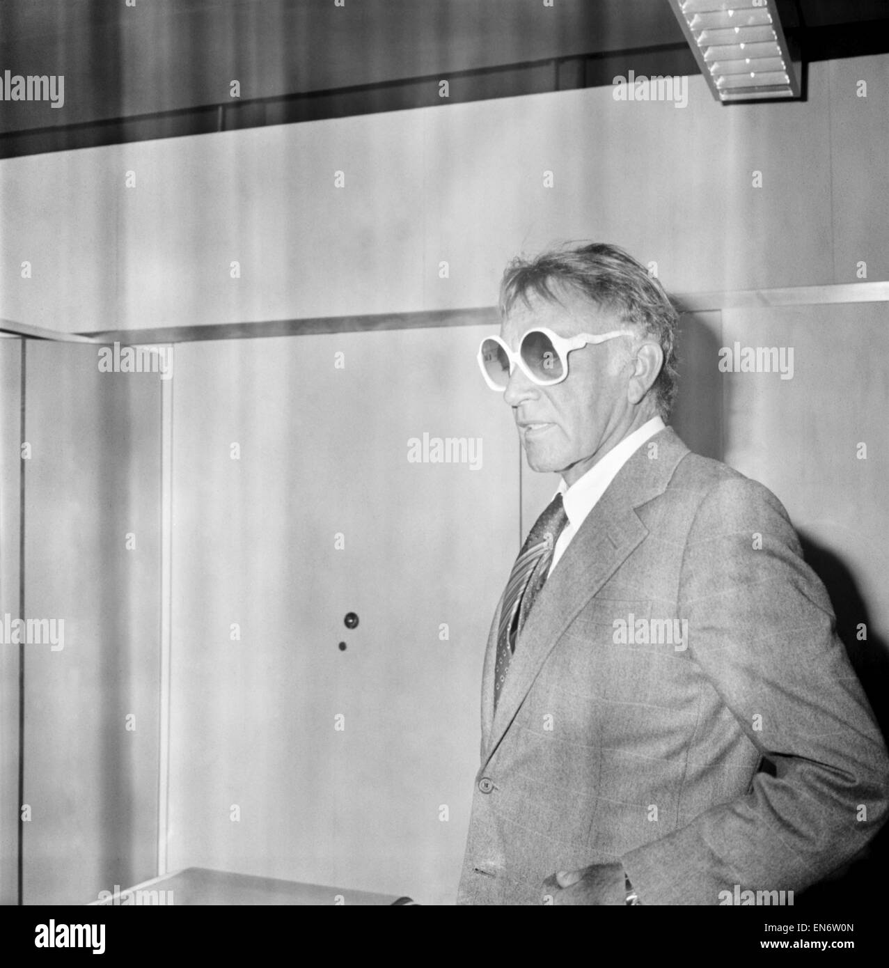 Richard Burton e di sua moglie Susie lasciando Heathrow per la loro casa a Ginevra. Ha rapidamente preso in prestito di occhiali da sole da una vecchia amica Valeria Douglas, - dicendo che il sole era troppo luminoso, nel corridoio della sala partenze. Luglio 1978 Foto Stock